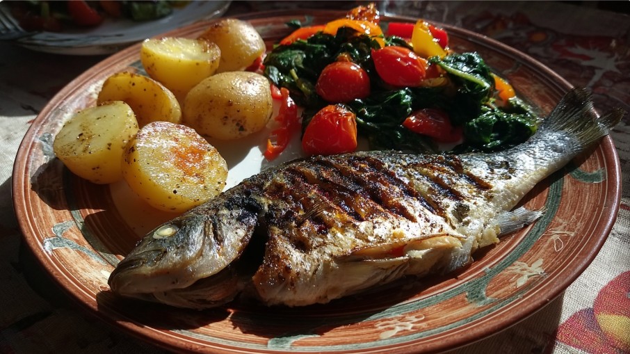 дорадо в духовці рецепт з картоплею та овочами на тарілці