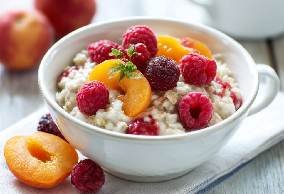 Вівсяна каша з фруктами і ягодами у глибокій тарілці