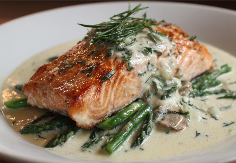 Лосось у вершковому соусі з квасолею на тарілці.