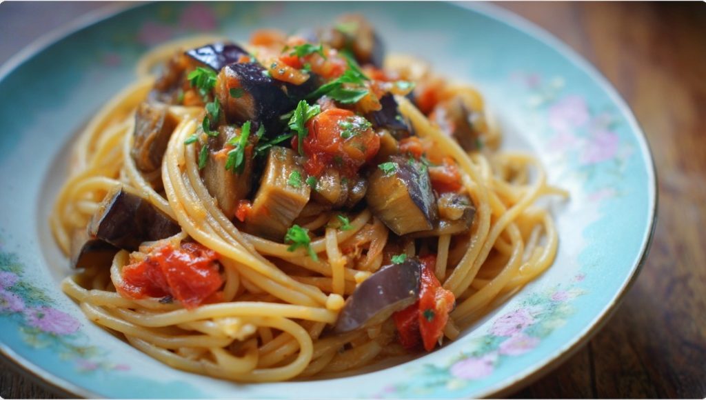 Спагеті з баклажанами та томатним соусом на декоративній тарілці.