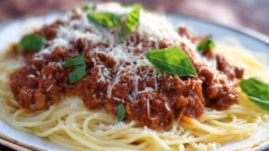 Коли паста болоньезе готова, злийте воду та додайте пасту до соусу