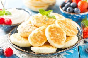 Подавайте сирники гарячими зі сметаною, варенням або медом і ягодами