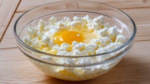 Великій мисці з'єднайте сир, яйця, цукор, сіль і ванільний екстракт до однорідної маси.