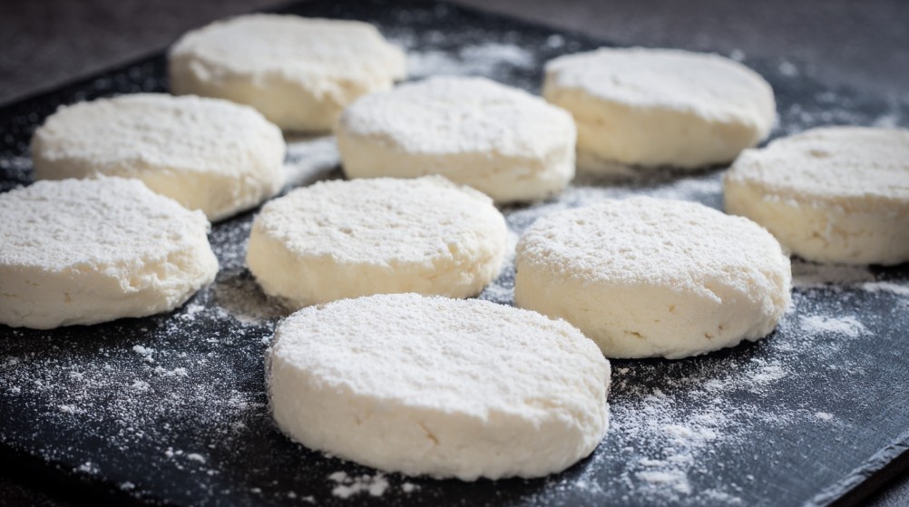 Заготовки сирників з сирного тіста на робочій поверхні