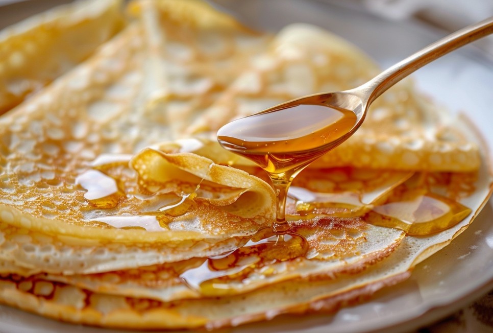 Млинці з медом, що стікає тонкою цівкою