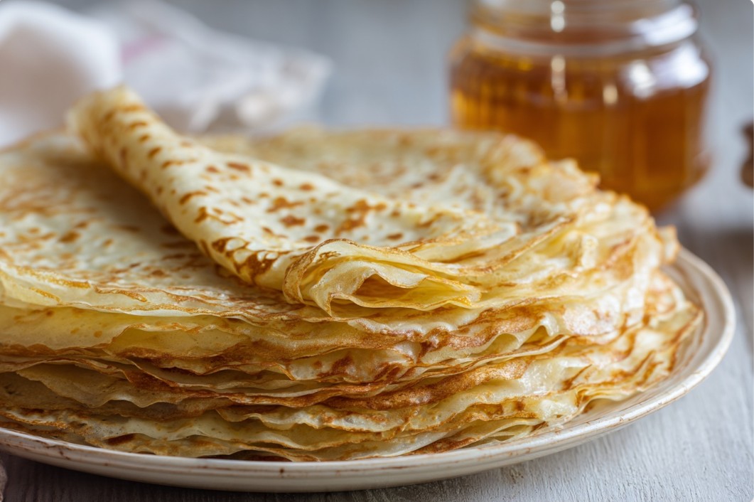 Тонкі золотисті млинці на молоці